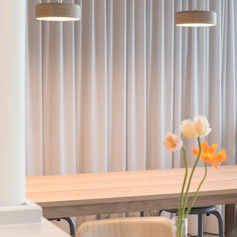 Good Green Deli: modernes Restaurant mit hellen Tischen und Blumen