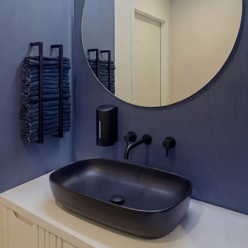 Linklaters Frankfurt: sehr modernes Bad mit rundem Spiegel und dunklen Waschbecken 