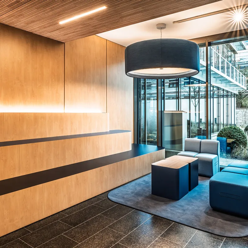BFV Office4you – Lounge mit blauen Barhockern und offener Technikdecke