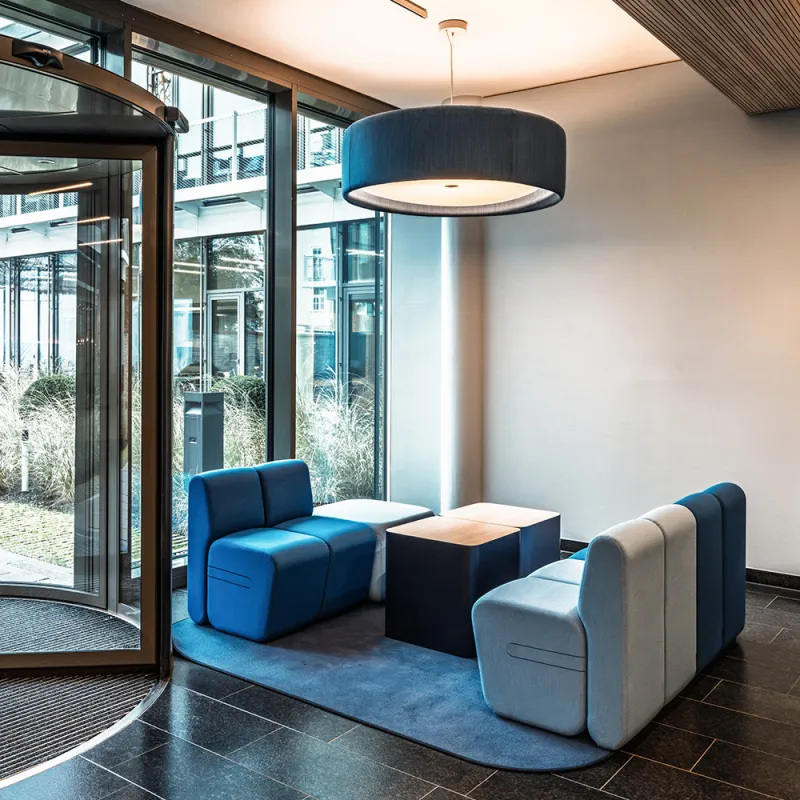 BFV Office4you – Lounge mit blauen Barhockern und offener Technikdecke