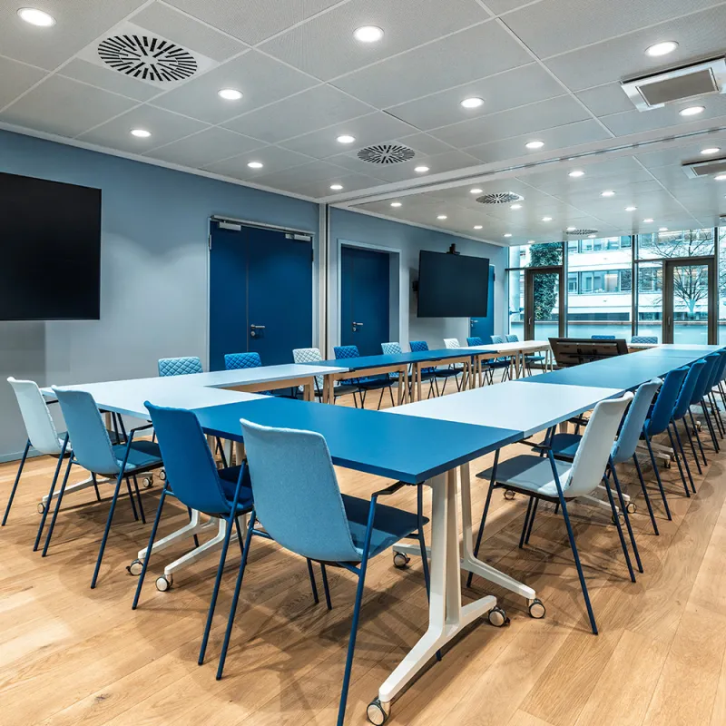 BFV Office4you – Lounge mit blauen Barhockern und offener Technikdecke